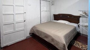 Un dormitorio con cama, armario y equipo de aire acondicionado.