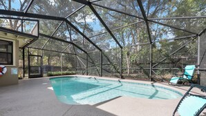 A covered swimming pool with a clear view of the surrounding trees, a lifebuoy, and a sign indicating pool rules. - Midcentury Marvel 5-bedroom pool house – walk to UF Stadium & Campus (Gainesville)