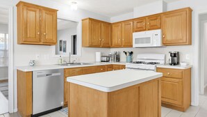 Una cucina moderna con mobili in legno, forno a microonde integrato e lavastoviglie.