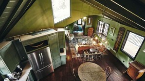 Une cuisine compacte équipée d’un réfrigérateur, de meubles en bois et d’un coin repas avec une table et des chaises.