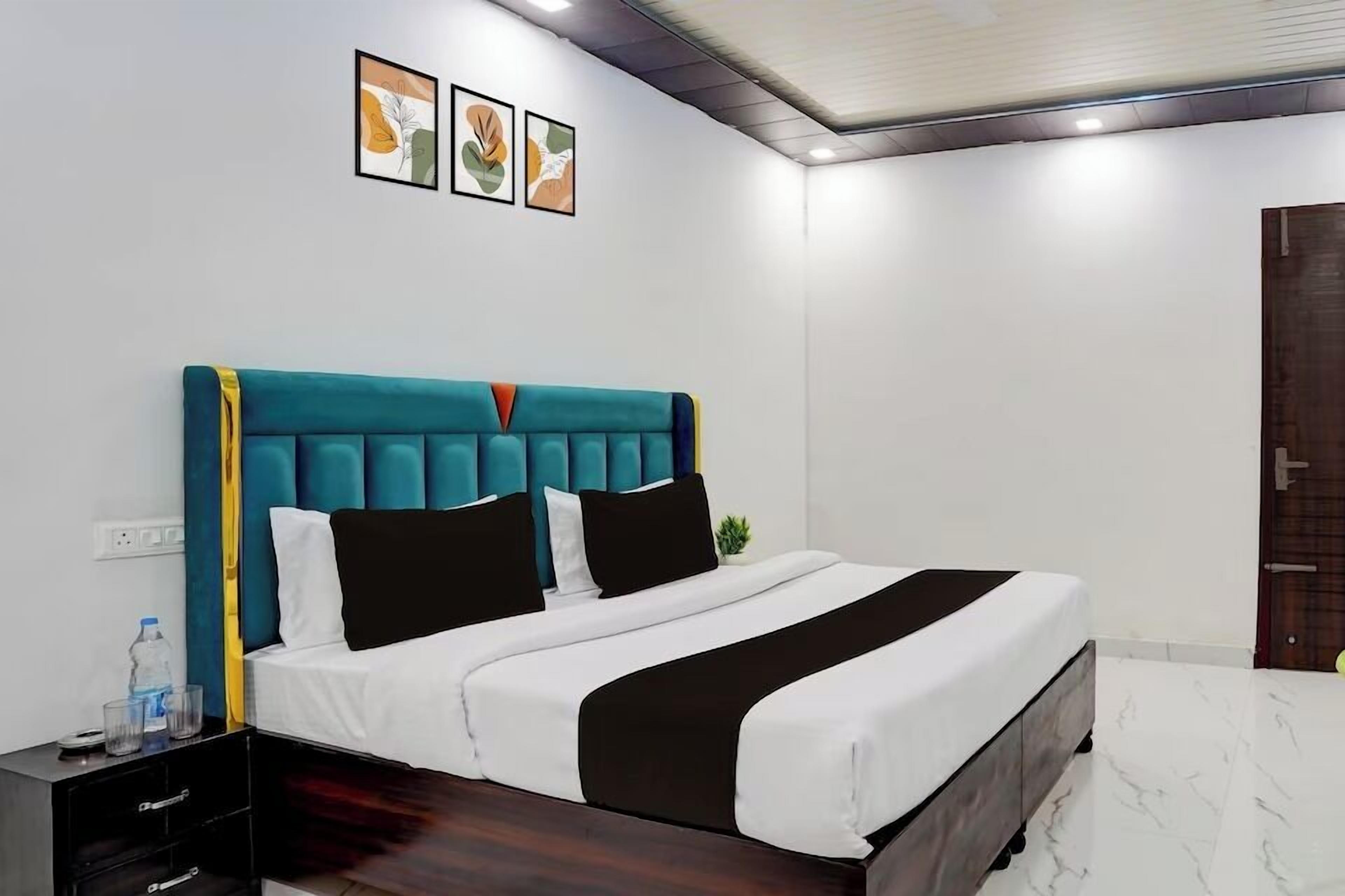Una habitación de hotel moderna con una cama grande, una mesita de noche y una pequeña planta en maceta.