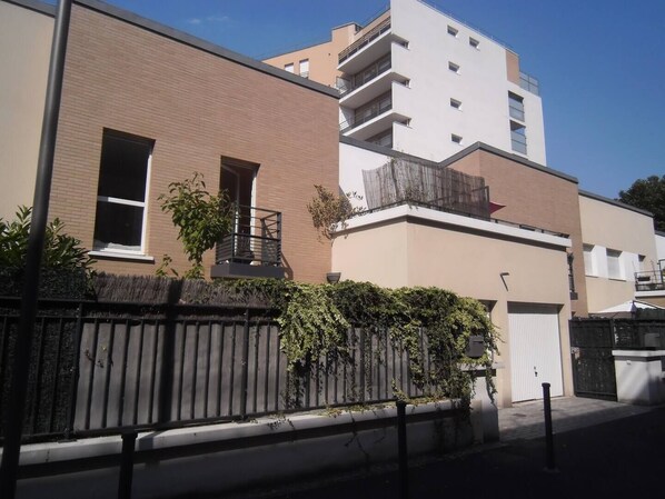 Ein modernes Apartmenthaus mit Backsteinfassade, einem Balkon und einem verschlossenen Eingang.