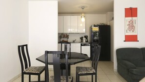 A compact living space with a dining area, kitchenette, and a sofa. - Town house 1000 metres from Paris (Saint-Ouen-sur-Seine)
