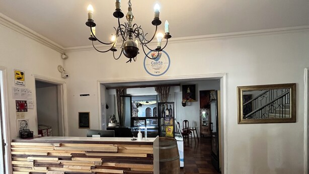 Un espace d’accueil avec un comptoir en bois, un lustre et une enseigne placée au-dessus du comptoir.