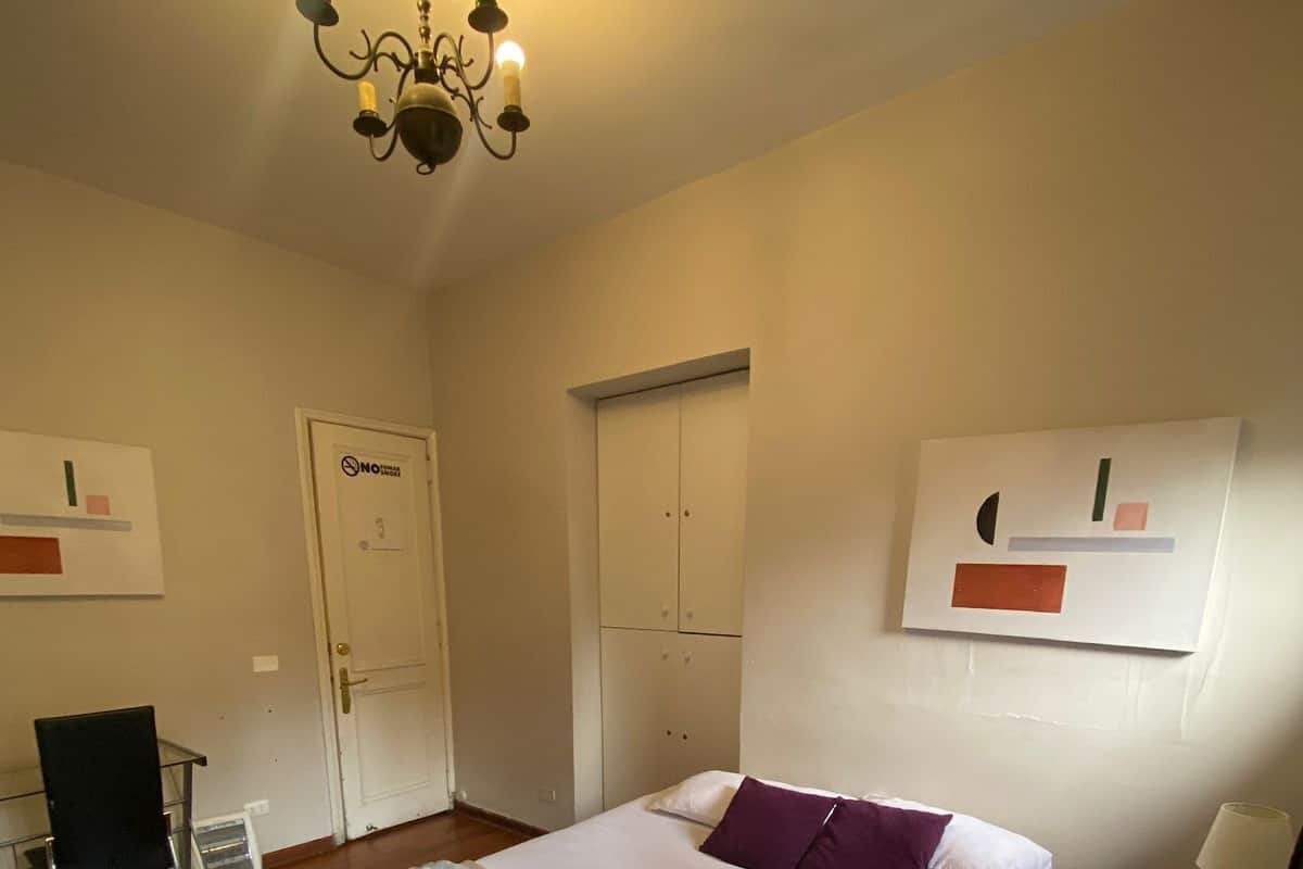 Een hotelkamer met een bed, een bureau, een stoel, een kledingkast en een pronkstuk.
