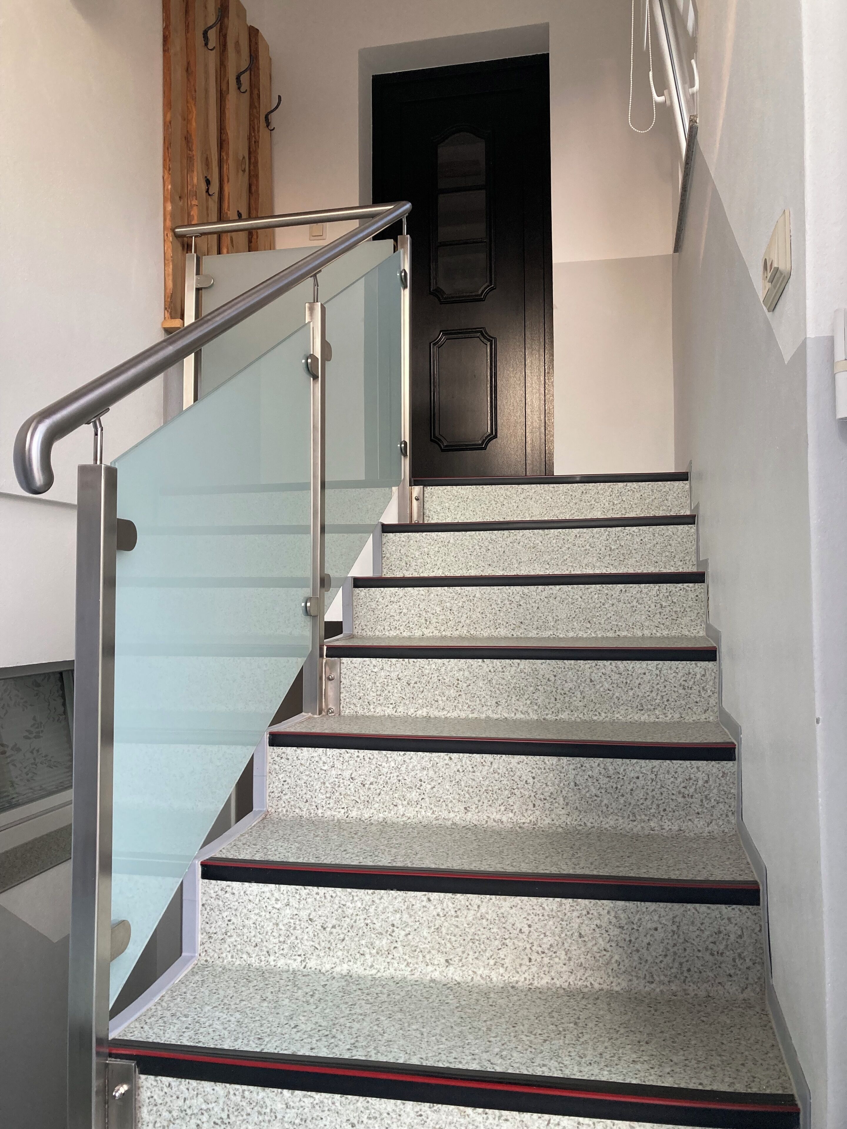 Eine Treppe mit Glasgeländern und Granitstufen.