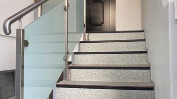 Eine Treppe mit Glasgeländern und Granitstufen.