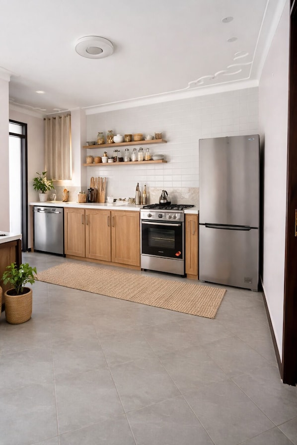 A modern kitchen with wooden cabinets, a stainless steel refrigerator, and a built-in oven.