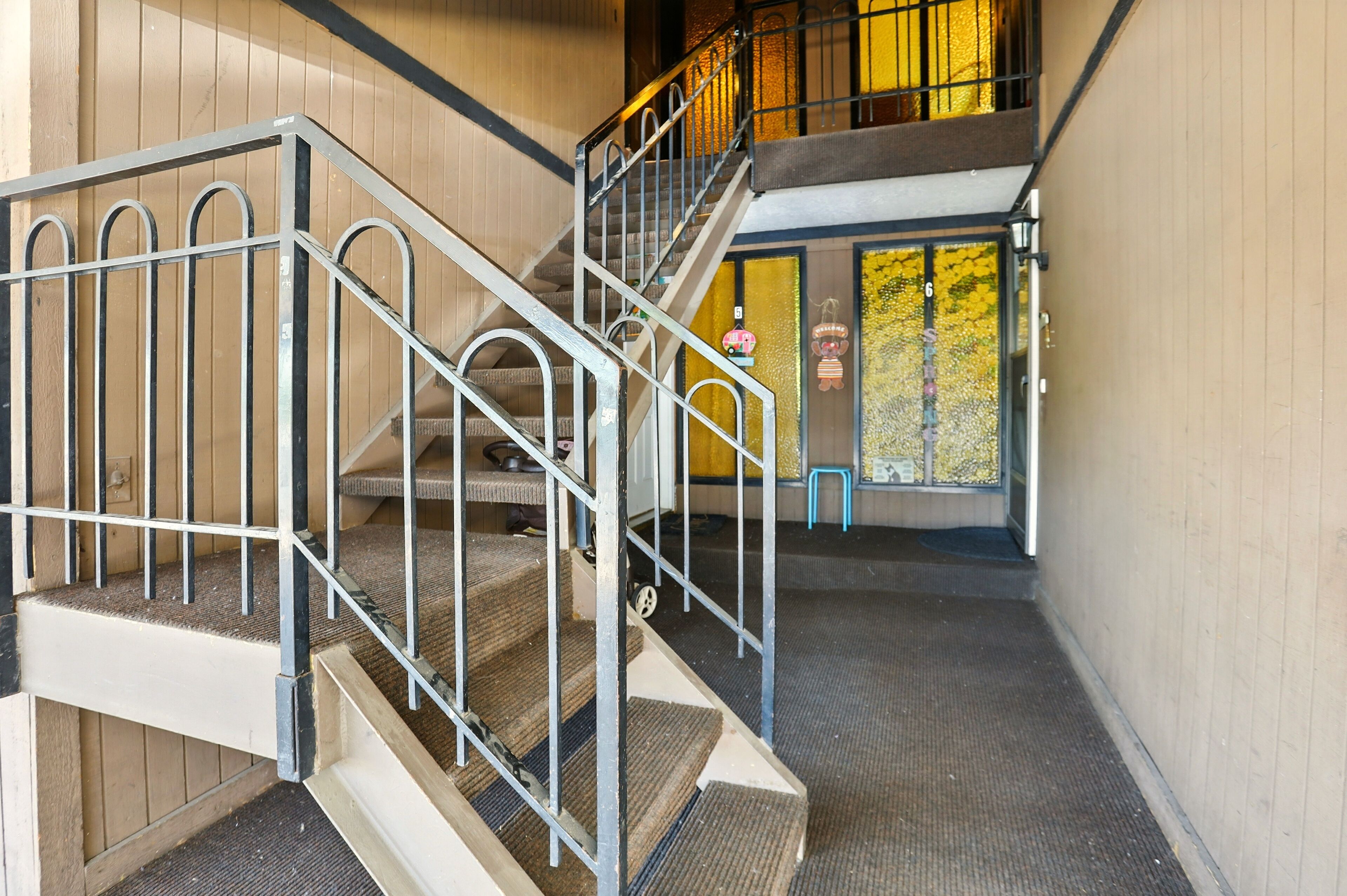 Un escalier avec des rampes en métal menant à un deuxième étage.