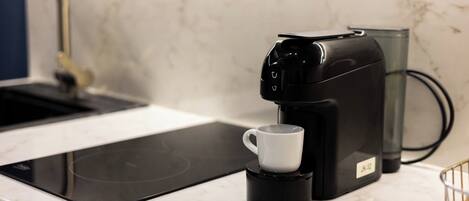 A coffee maker with a cup on a kitchen counter.