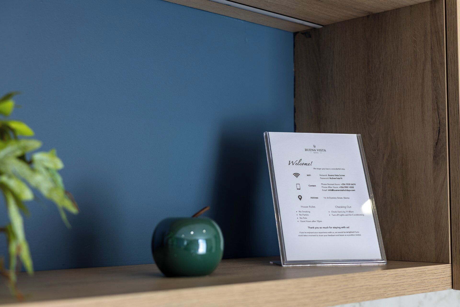 Un panneau d’accueil indiquant les informations sur l’hôtel, notamment les détails du réseau Wi-Fi, les numéros de téléphone et le règlement intérieur.