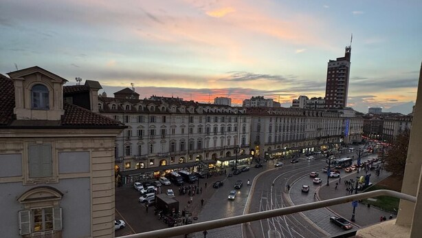 Une vue sur la ville, avec des bâtiments historiques et une intersection animée, au coucher du soleil.