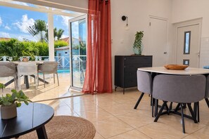 A modern kitchen with a dining area, a sliding glass door leading to a poolside, and a view of the outdoors. - Quietly located vacation villa with a private pool (Fontein)