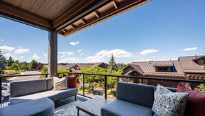 An outdoor seating area with a view of residential buildings and trees. - Beautiful end unit home with big horizon views! (Bend)