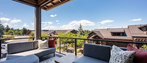 An outdoor seating area with a view of residential buildings and trees.