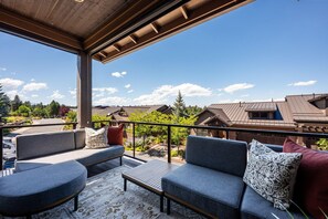 An outdoor seating area with a view of residential buildings and trees. - Beautiful end unit home with big horizon views! (Bend)