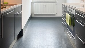 Una cocina moderna con electrodomésticos de acero inoxidable, una ventana con vistas y una lámpara sobre el fregadero.