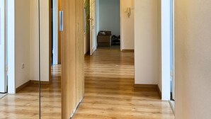 Un interior moderno con pisos de madera, un arco central e iluminación colgante.