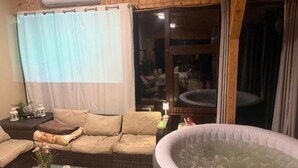 Ein gemütlicher Wohnbereich mit einer Couch, einem Couchtisch und einer Whirlwanne.