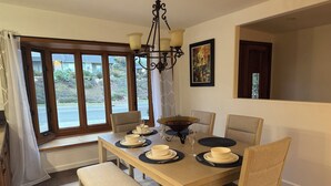 Ein Esszimmer mit Holztisch, gedeckt für vier Personen, einer Bank und einer Chandelier.