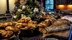 A buffet with various baked goods and a floral centerpiece. - Warm family run farmhouse in the national park of Haspengouw in Belgian Limburg (Nieuwerkerken)