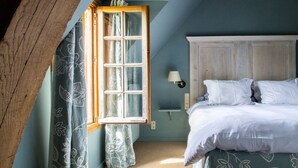 A bedroom with a bed, a nightstand, a lamp, and a window with curtains. - Warm family run farmhouse in the national park of Haspengouw in Belgian Limburg (Nieuwerkerken)