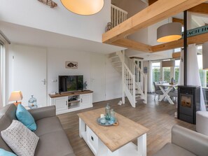 Ein modernes Wohnzimmer mit einer Couch, einem Couchtisch, einem Fernseher und einem Kamin.