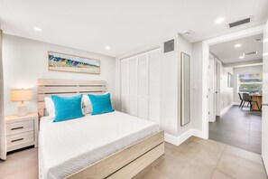 Une chambre à coucher comprenant un lit, une table de chevet, un bureau et une armoire.