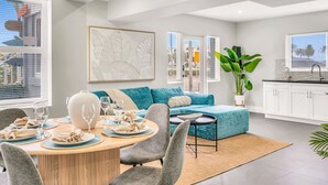 Ein modernes Wohnzimmer mit Essbereich, einer Couch und einer Küche.