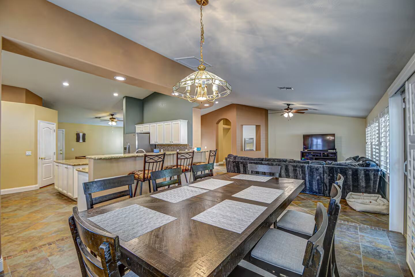 A spacious kitchen with a dining area, a large island, and a cozy living room with a TV.