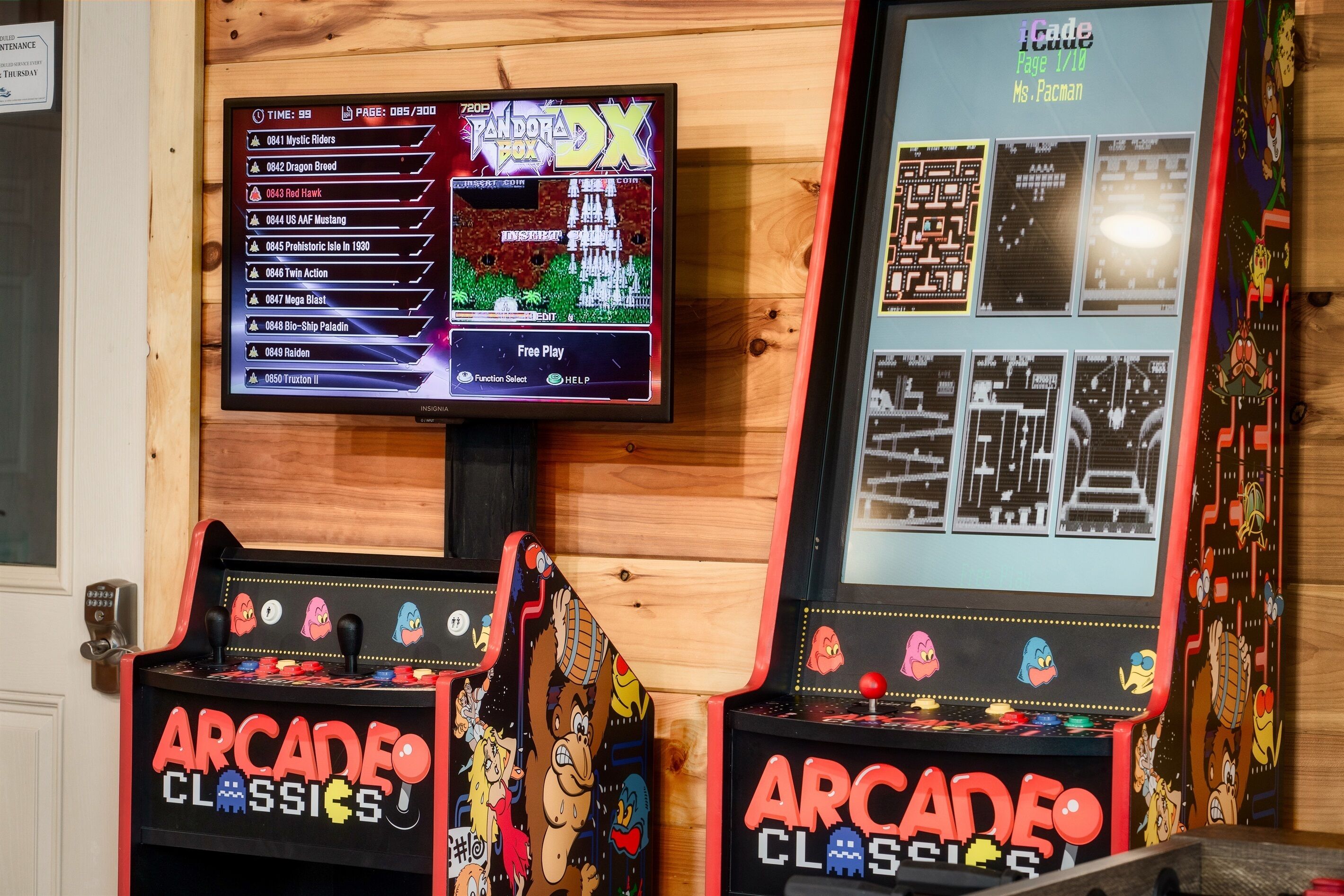 Two arcade machines with classic games, a wooden wall, and a door with a keypad.
