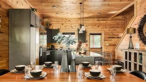 A wooden interior with a dining table set for six, kitchen cabinets, a central island, and pendant lighting. - Free Dollywood Tix•Heated Pool•GameRoom•Modern (Sevier)