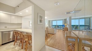 Ein modernes Hotelzimmer mit Küche, Essbereich und einem Balkon mit Meerblick.