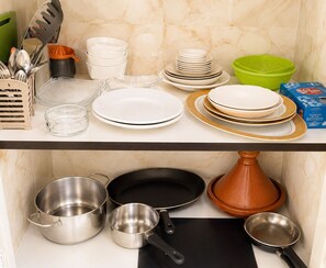 A kitchen counter with various dishes, utensils, and cookware. - Large Studio Fiber optics IPTV (Marrakech)