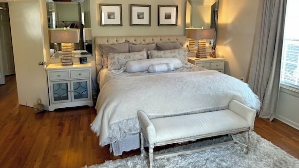 A bedroom with a large bed, two bedside tables, a ceiling fan, and a window with curtains. - 3-bedroom Cottage new LSU! (Baton Rouge)