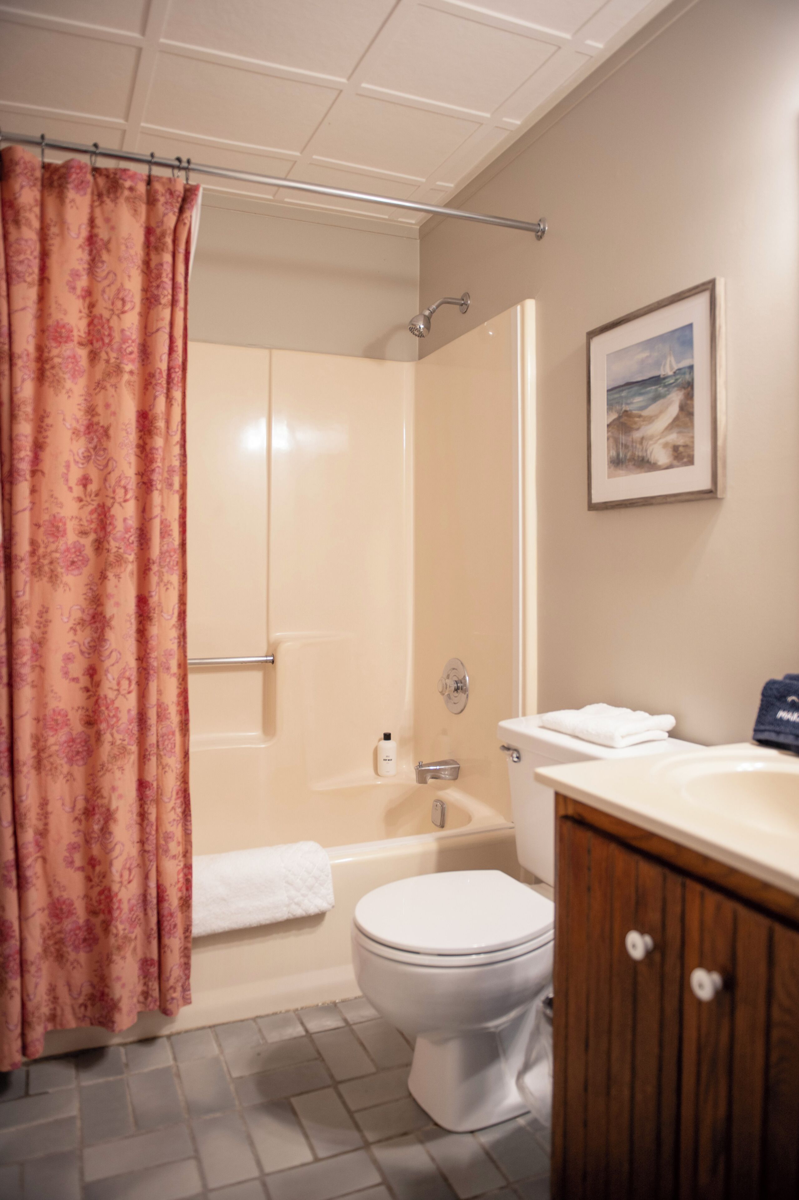 A bathroom with a shower, toilet, and sink.