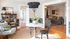 Een moderne woonkamer met een ronde eettafel, een bank en een kroonluchter.