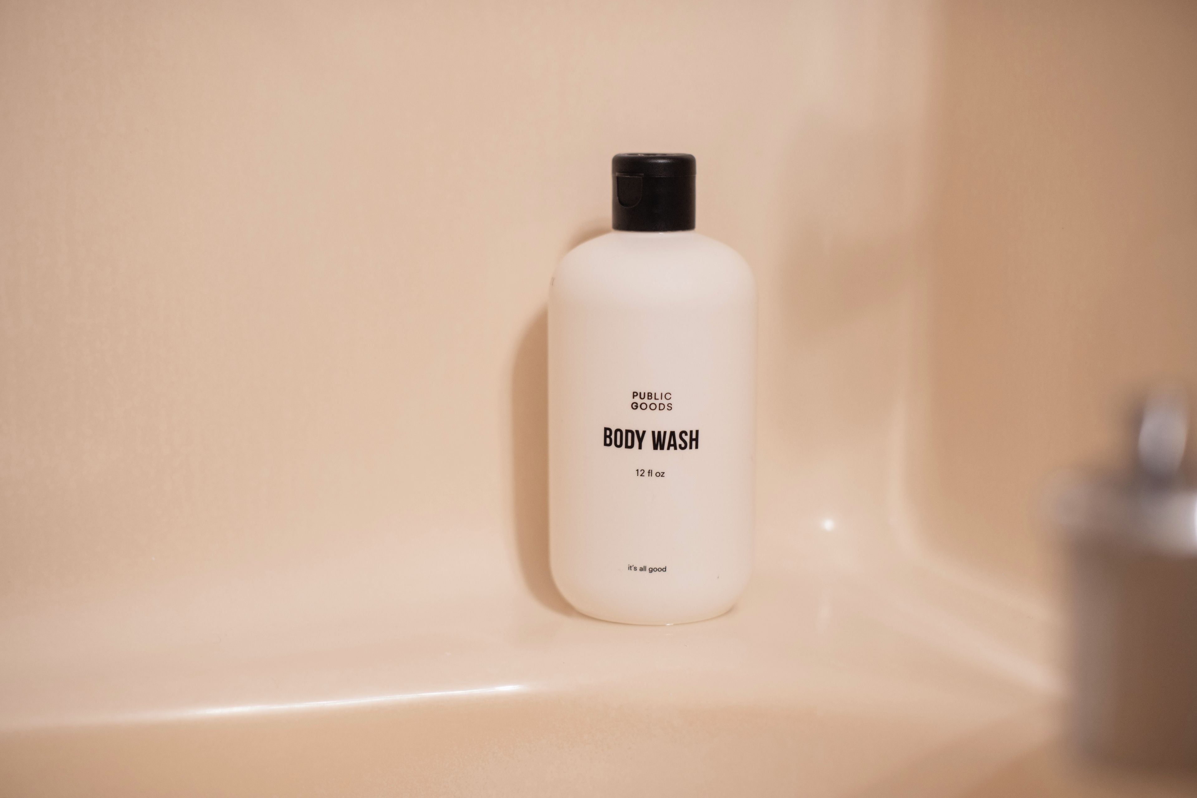 A bottle of body wash on a beige countertop.