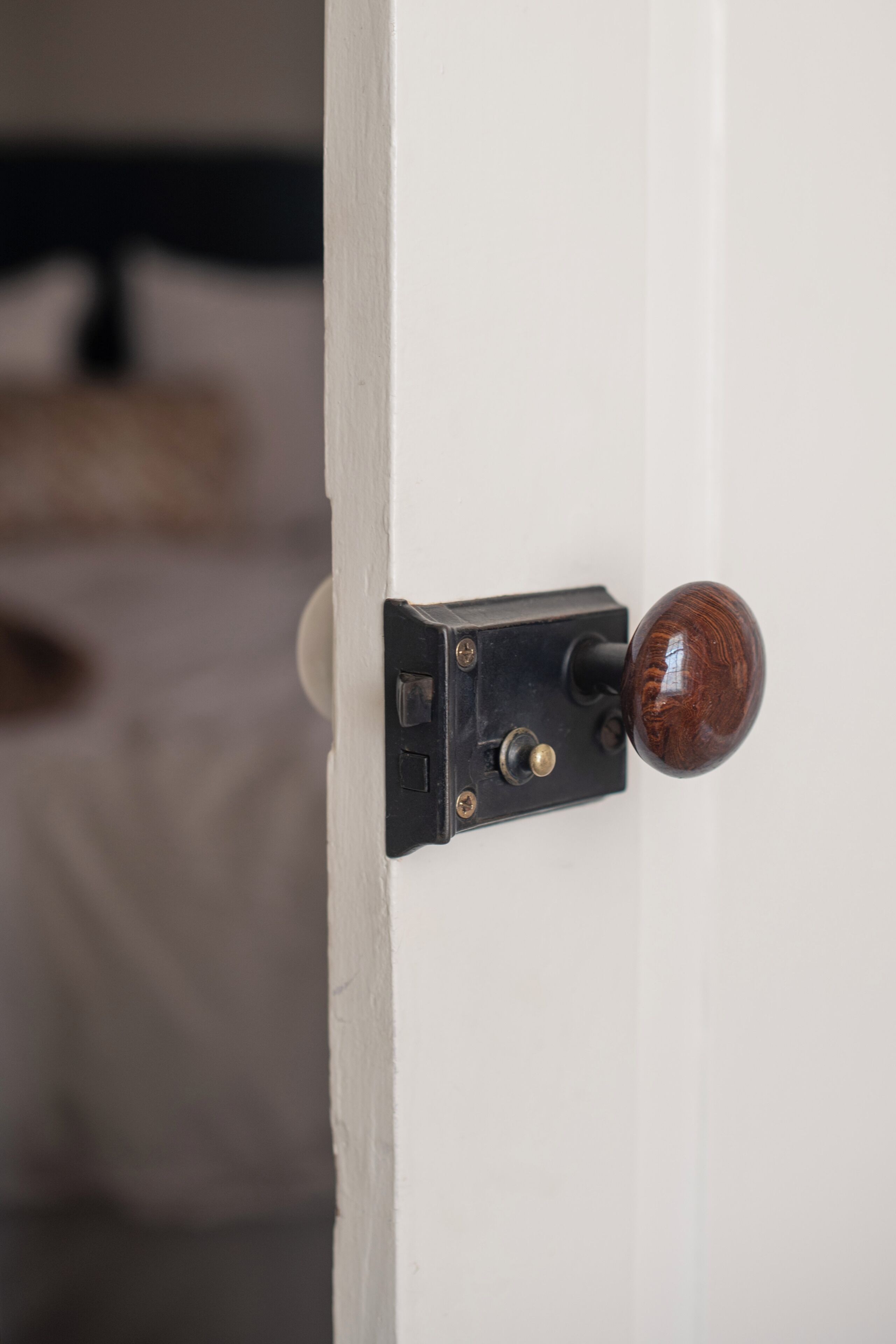 A door with a wooden knob and a black latch mechanism.