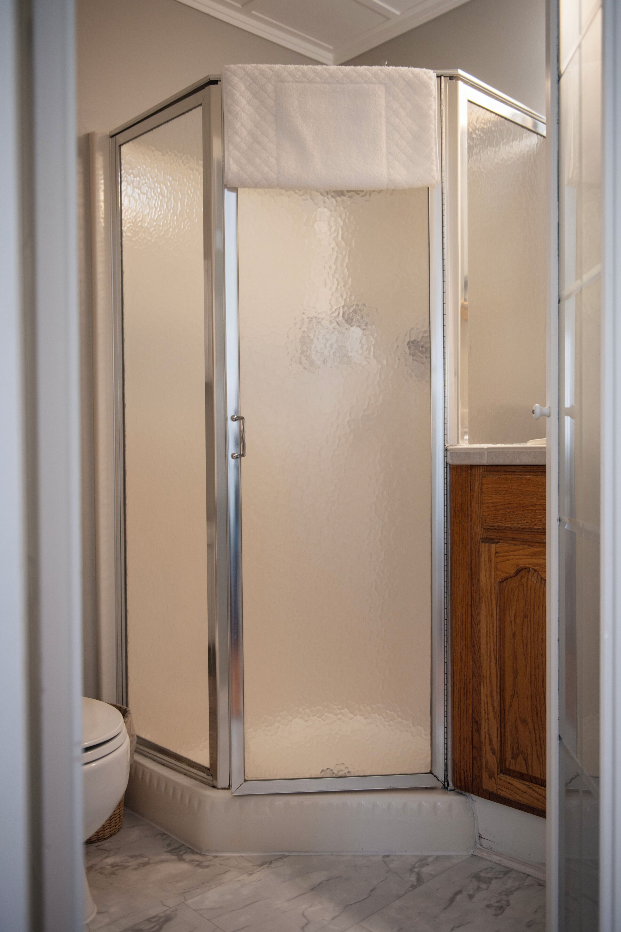 Une salle de bain avec une douche, des toilettes et un meuble en bois.