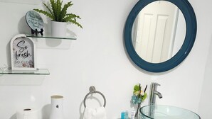 A modern bathroom with a toilet, sink, and mirror.