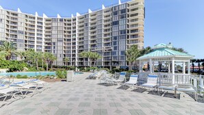 A hotel with multiple floors, a pool area with lounge chairs, and a gazebo. - Billie Jeans Bungalow! Cozy Edgewater Condo w/ Resort Amenities, Sleeps 6 (Panama City Beach)