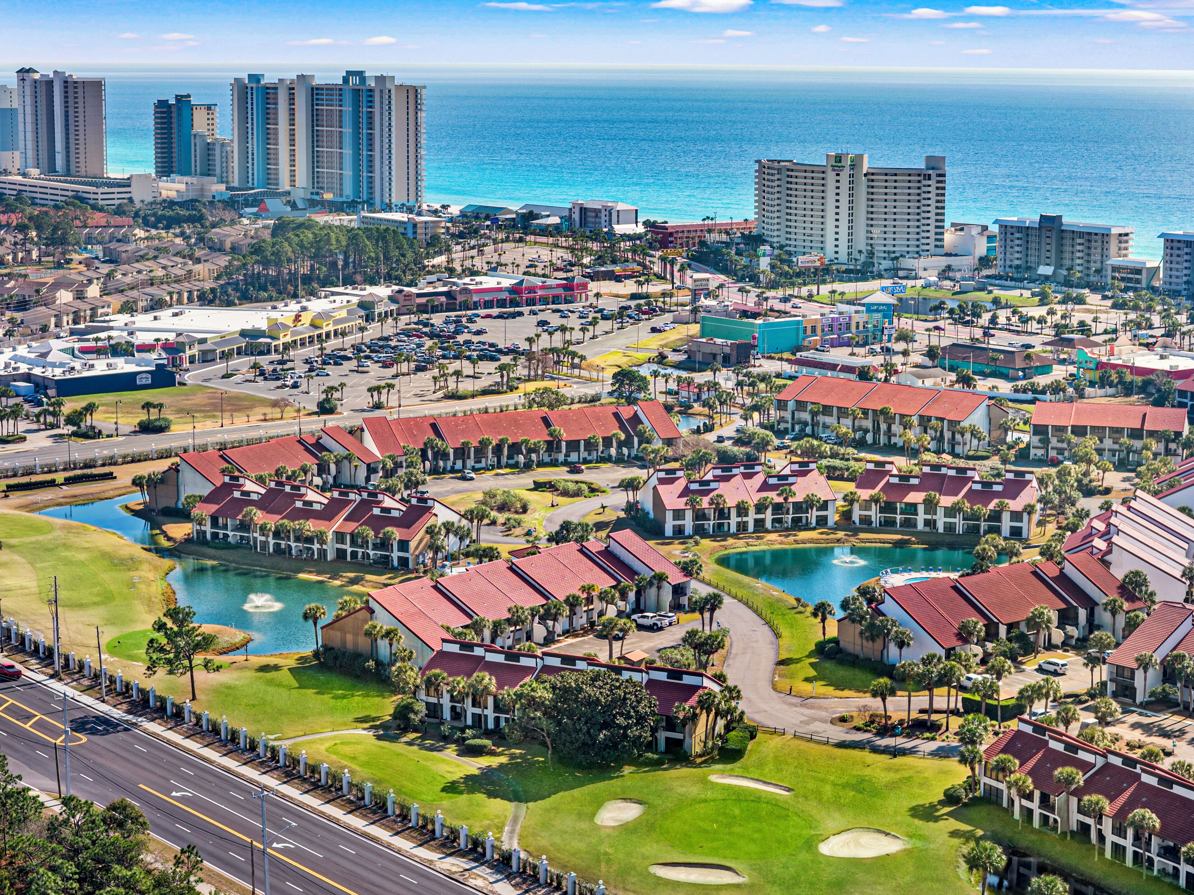 Um resort com vários edifícios, um porto de iates e vista para o oceano.