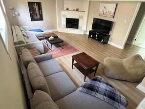 A modern living room with a fireplace, a sofa set, a television, and a coffee table.
