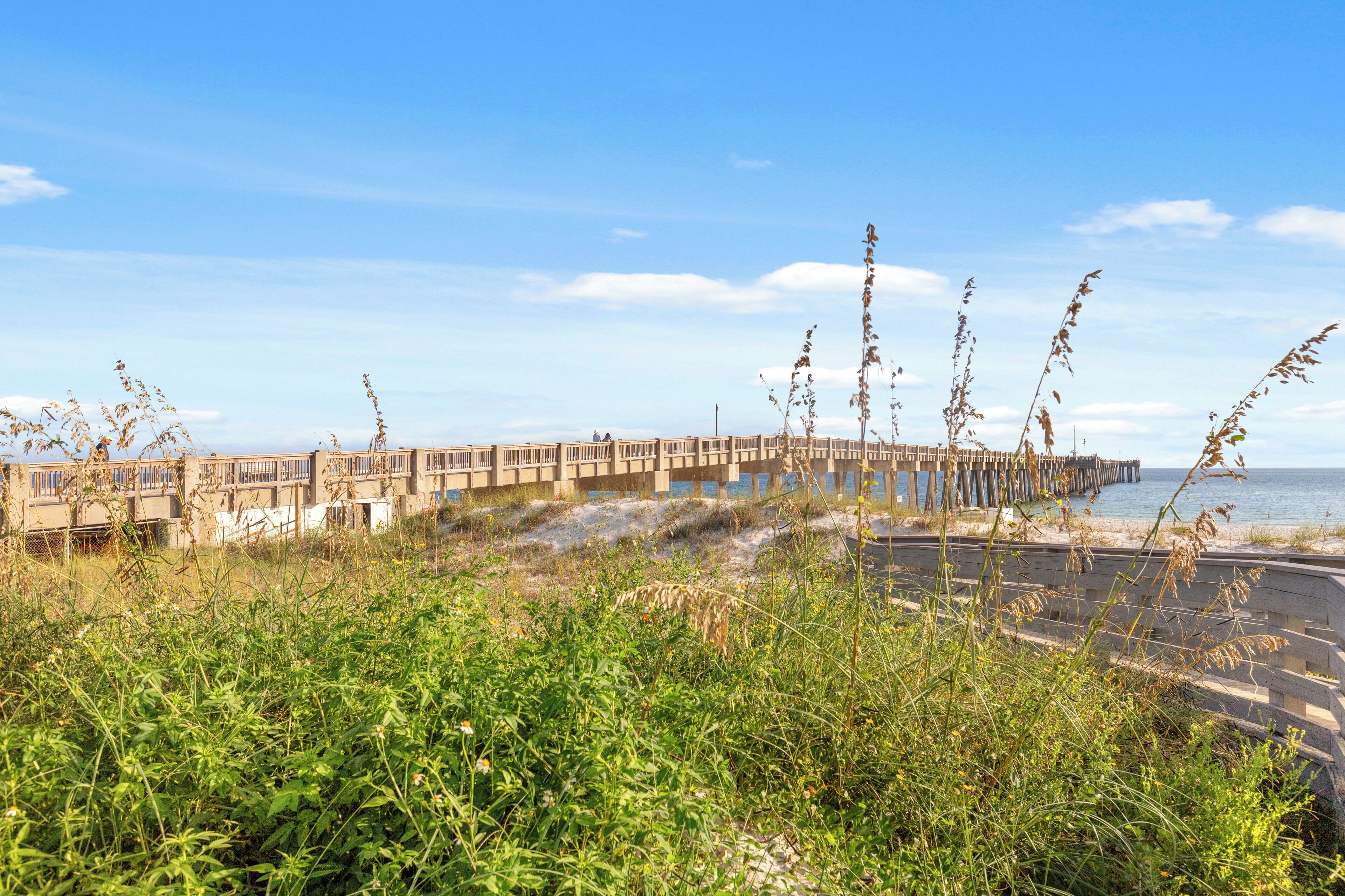 A coastal pier extending into the sea with a series of balconies and a walkway.
