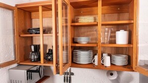 A wooden cabinet with multiple shelves containing plates, bowls, cups, and a coffee maker. - MHV Milagres - Casa da Villa 08, Casa em Villa (Passo de Camaragibe)
