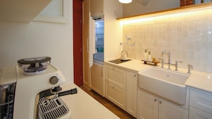 Een keuken met een ingebouwde kookplaat, een spoelbak en een kast met een raam.