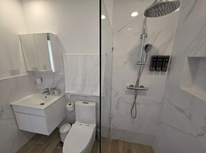 A modern bathroom with a sink, toilet, and shower. - Oasis Turquesa Punta Cana Crystal Lagoon (Punta Cana)