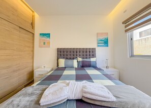 A bedroom with a large bed, two bedside tables, a wooden wardrobe, and a window. - Villa Koi Oasis Punta Cana (Punta Cana)
