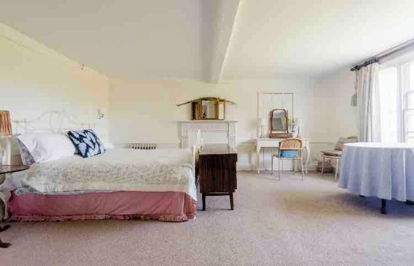 Una camera da letto con un letto, una scrivania, una sedia e un tavolo.